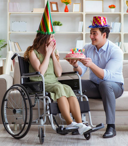 和残疾人一起庆祝生日的年轻家庭