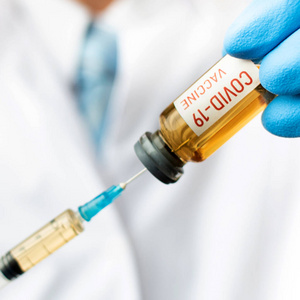 医生或实验室拿着nCoV冠状病毒COVID疫苗的试管