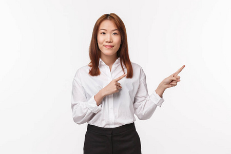 成功的亚洲美女家教，女企业家在镜头前指指点点，微笑愉快，讲述产品特点广告白色背景