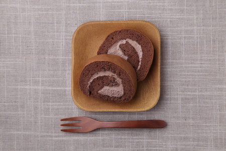 台布上盘子里的巧克力卷蛋糕图片