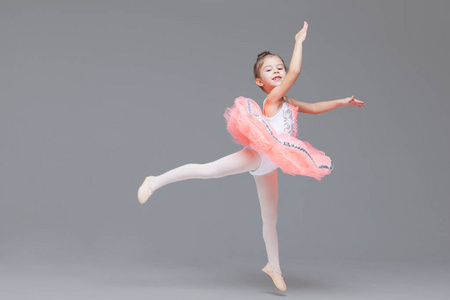 可爱可爱的芭蕾舞演员穿着粉色芭蕾舞裙练习芭蕾舞