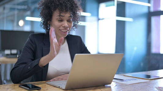 兴高采烈的非洲女商人在办公室用笔记本电脑进行视频聊天