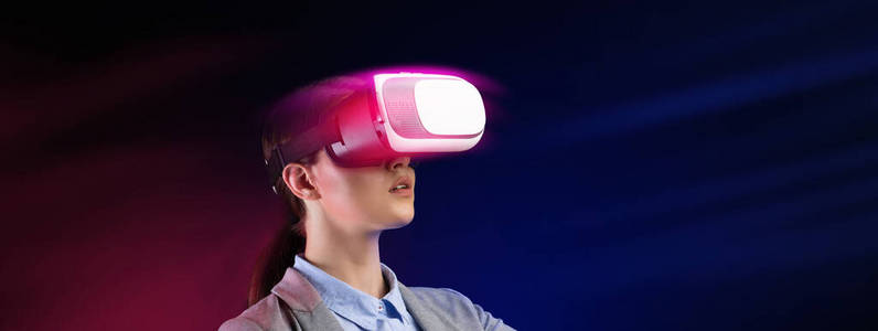 商业和技术。女商人戴着VR耳机，在彩色背景下工作，拼贴出空白