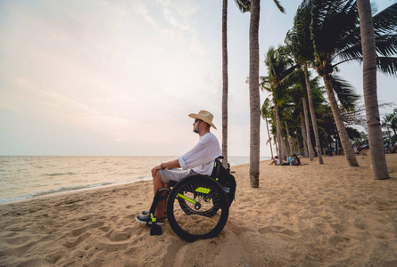 沙滩上坐轮椅的残疾人。