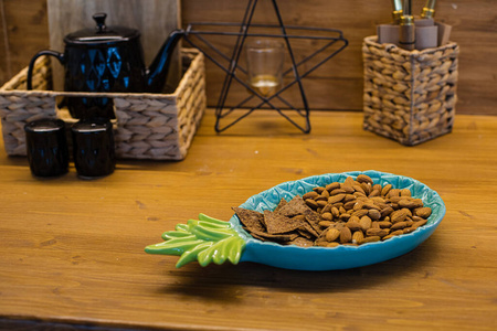 盘子里有很多饼干，棕色的桌子上有不同的厨房用具