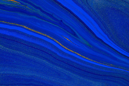 流畅的艺术质感。背景与抽象漩涡油漆效果。液体亚克力图片与彩色混合涂料。2020年经典蓝色。蓝色，金色和靛蓝四溢的颜色。