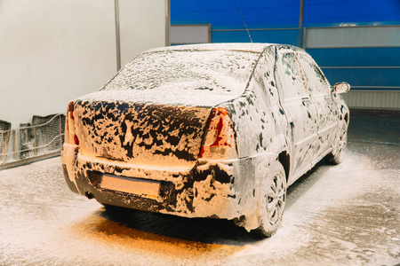 近距离清洁汽车概念在洗车。用肥皂洗车。洗车机