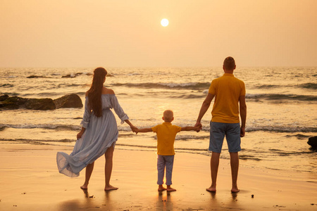 快乐的一家人在海滩上看日落