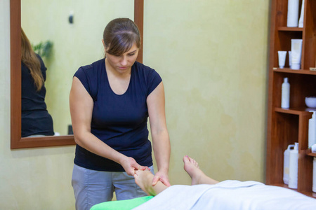 专业理疗师在水疗中心为一名妇女提供放松的按摩按摩疗法