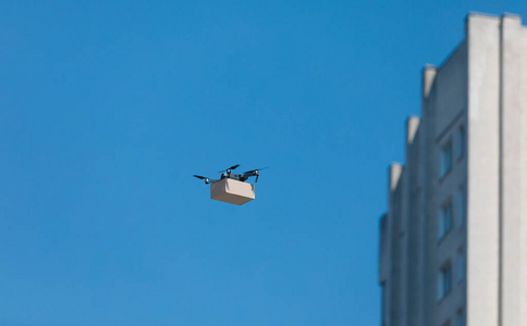 现代化的电动无人机，纸板箱在镇上飞过