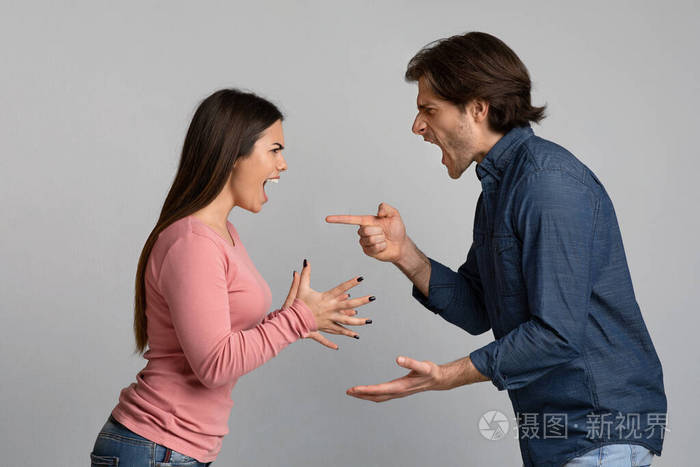 千禧一代夫妻在灯光的背景下吵架喊叫互相指责