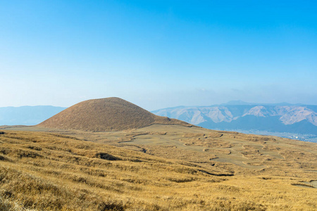 一月份的Komezuka，一个火山锥在麻生国公园。草地覆盖着周围的区域和它的表面。日本熊本县