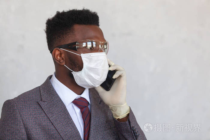 科维德19穿着西装的英俊的非洲黑人男子戴着医用面罩戴着防护眼镜手戴