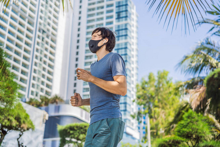 戴着医用面罩的男跑步者。在城市的背景下奔跑。冠状病毒大流行Covid19。运动，活跃的生命检疫外科消毒口罩保护