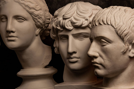 一组石膏半身像古代雕像人类的头在黑暗的背景下为艺术家。古代人脸的石膏雕塑。文艺复兴时期风格。学术主题。创意空白。