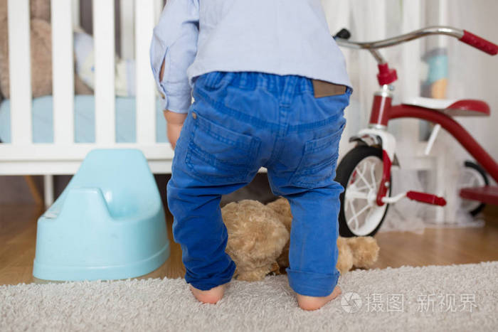 一个蹒跚学步的小男孩尿在裤子里在t