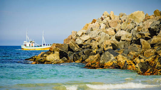 带渔船和石制防波堤的海景图片