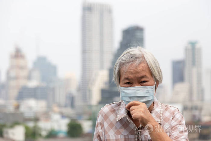 老年妇女戴口罩是因为城市建筑空气污染为背景,患病老人用医用口罩