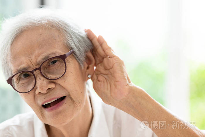 老年妇女听力困难,戴眼镜有听力障碍,老年人有听力障碍的观念照片