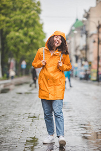 带帽雨衣微笑的年轻女子肖像图片