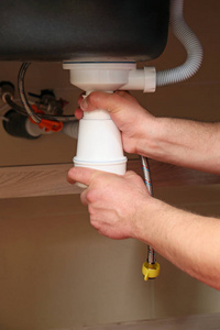 修理厨房水槽的水管工图片