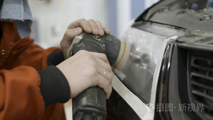 汽车修理工抛光车头的特写镜头轻艺术在汽车修理更新服务站工人正在用