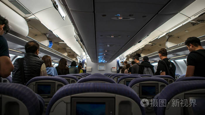 飞机内部过道上的乘客正在步行下飞机