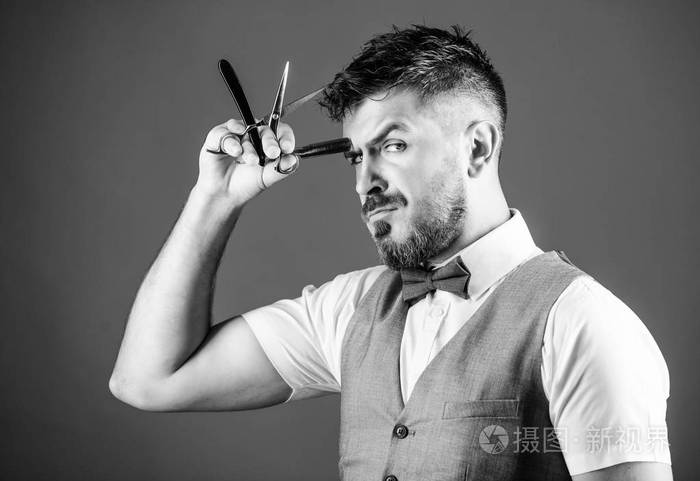 理发师的秘密拿着老式理发工具的理发师留着胡子的男人拿着剃须刀和