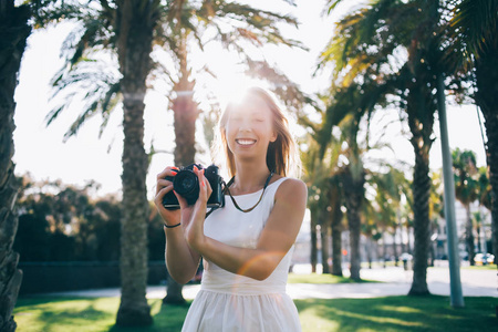 阳光下带着照相机的快乐女人图片