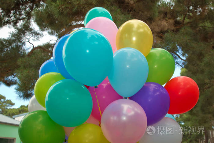 绿色背景下的一堆彩色气球为户外聚会准备了许多彩色的气球五颜六色的