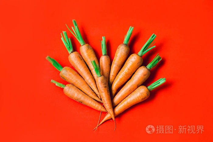 红色背景上有一些新鲜的胡萝卜