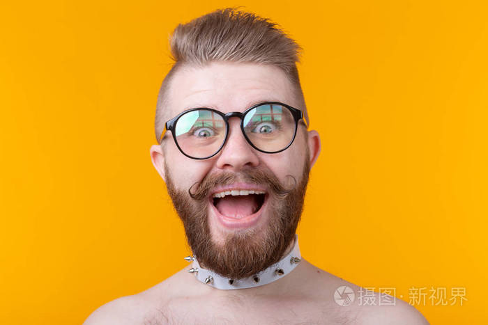 一个留着胡子和胡子的疯狂的年轻时髦男人在黄色背景上高兴地张嘴惊喜