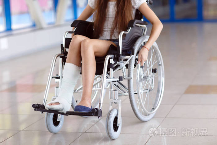 一个坐轮椅的小女孩站在医院的走廊上