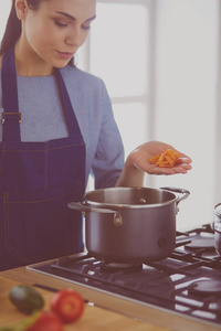 厨房里用木勺做饭的女人图片