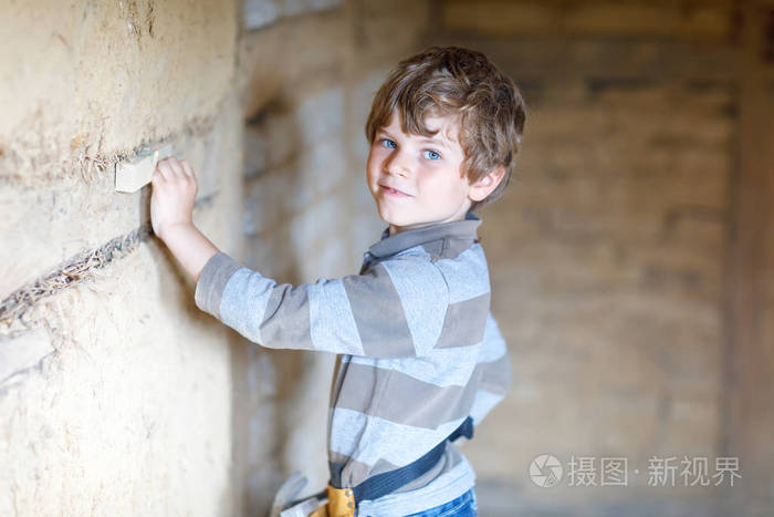 一个小男孩在工地上帮忙拿玩具工具