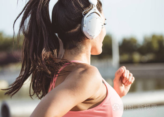 棕色迷人的委内瑞拉女人戴着大耳机跑步听音乐