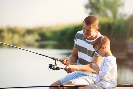 爸爸和儿子在晴天一起钓鱼图片