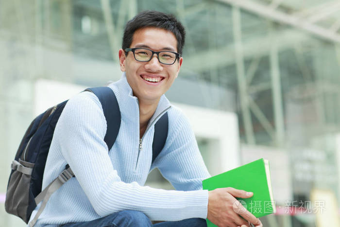 一位年轻的亚洲男大学生在校园里的照片