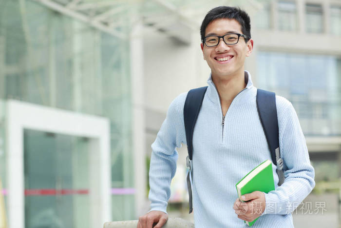 一位年轻的亚洲男大学生在校园里的照片