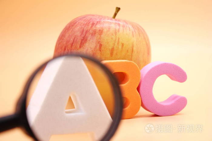 苹果和放大镜旁边的英文字母abc