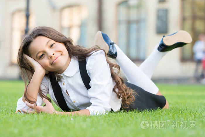 很高兴.放学休息.可爱的小学生.女孩躺在绿草丛中