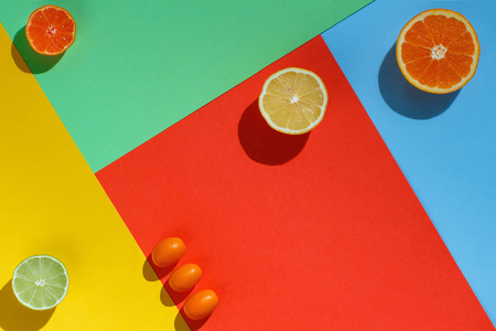 柑橘类水果在珊瑚红，黄，蓝，绿的背景上照片