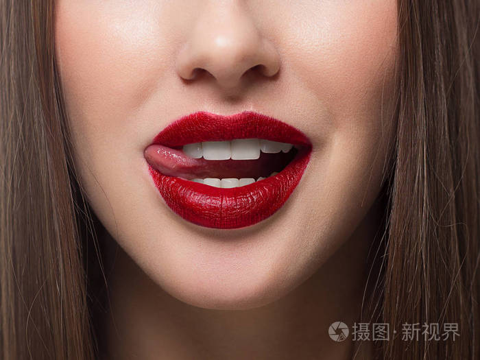 性感女性嘴唇特写与舌头清洁的皮肤和清晰的嘴唇轮廓用流行的红色唇膏