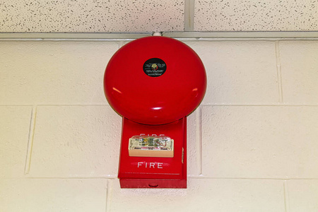 挂在白砖墙上的红色火警警报器图片