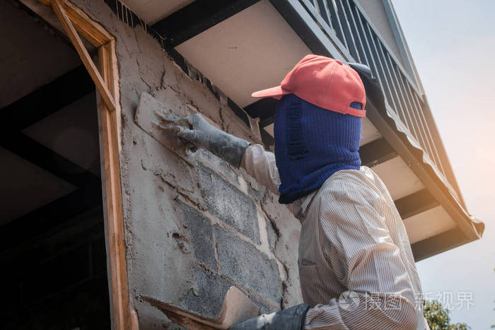 建筑工人用水泥浆粉刷建筑墙面