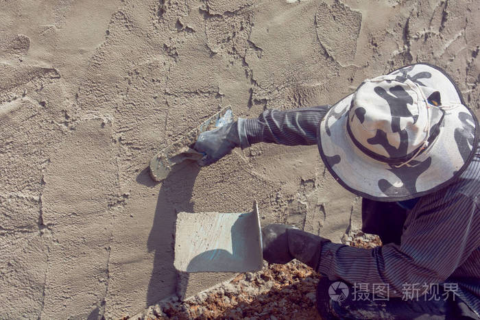 建筑工人用水泥浆粉刷建筑墙面