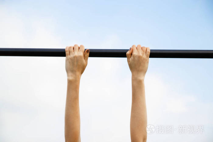 阳光明媚的一天女孩通过了公园单杠的拉起标准