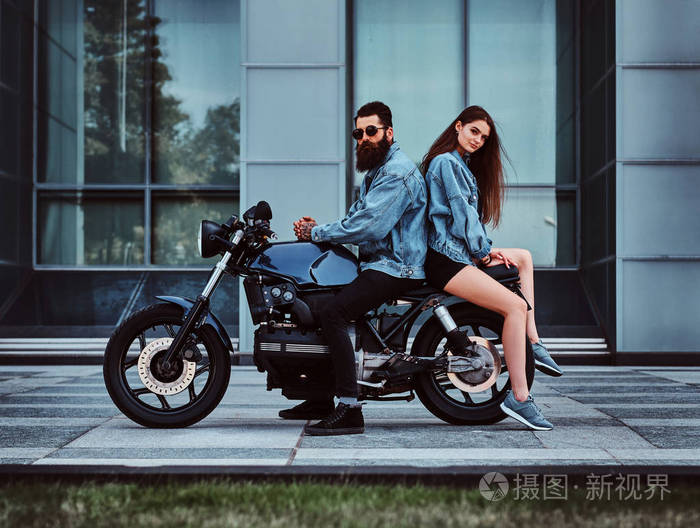 一对情侣骑着摩托车穿着牛仔夹克的肖像