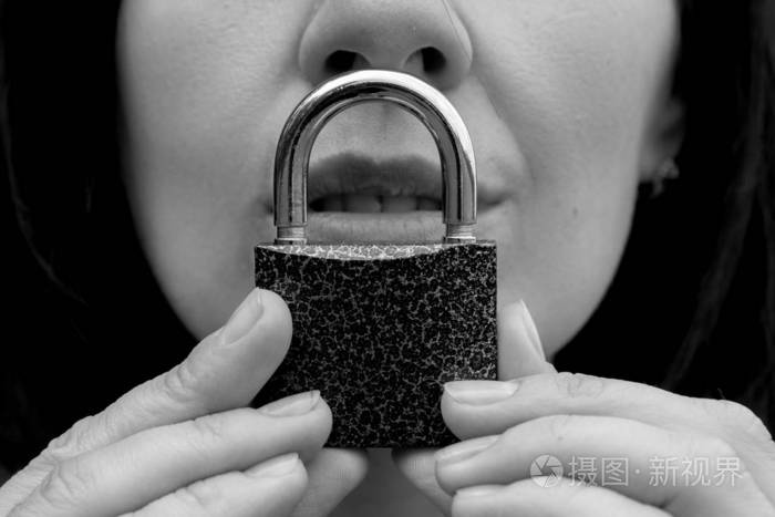 一个嘴上带锁的女人保持沉默的概念肖像.白人女人闭嘴