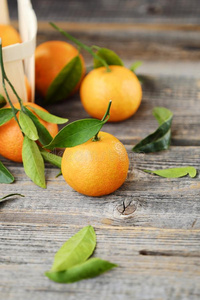 新鲜的美味的橘子和树叶向木制的表